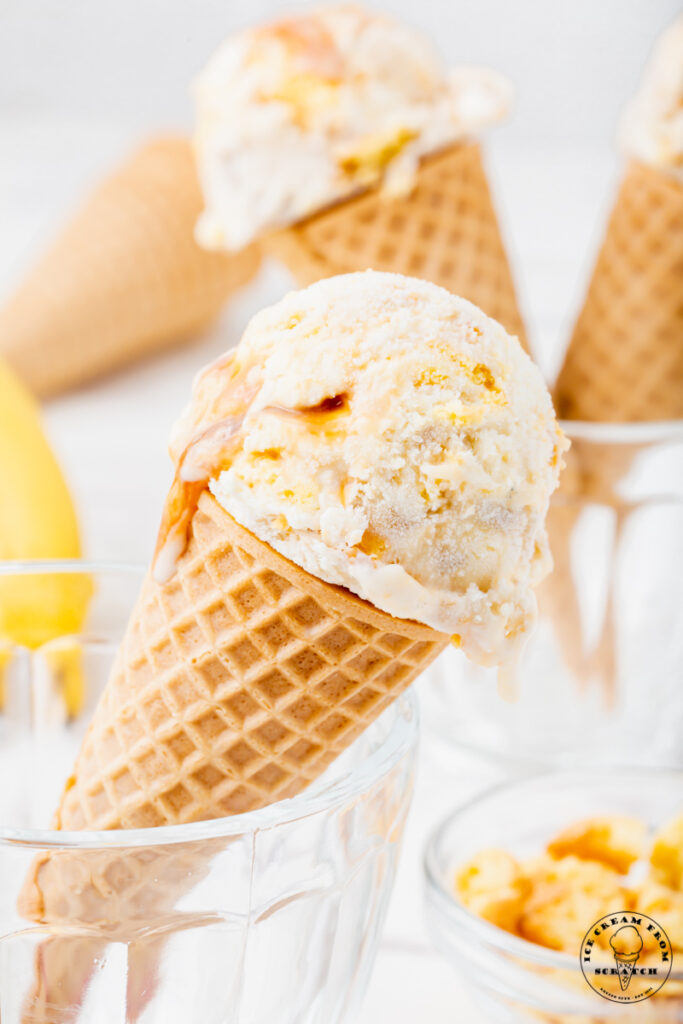 Banoffee pie ice cream in 3 sugar cones, placed in glass ice cream dishes.
