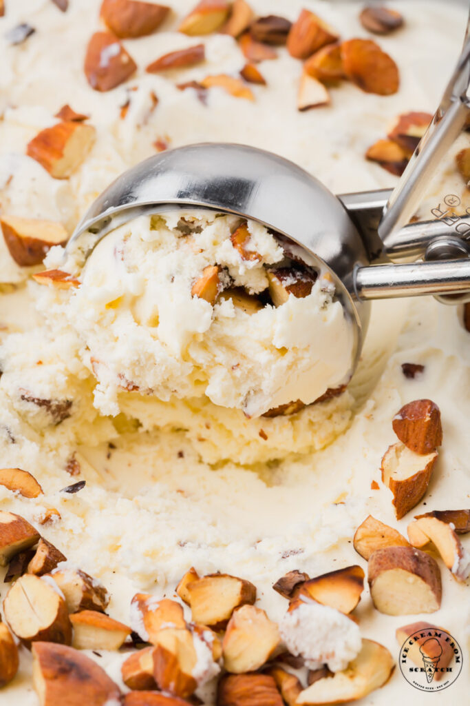 almond ice cream being scooped with a metal ice cream scoop