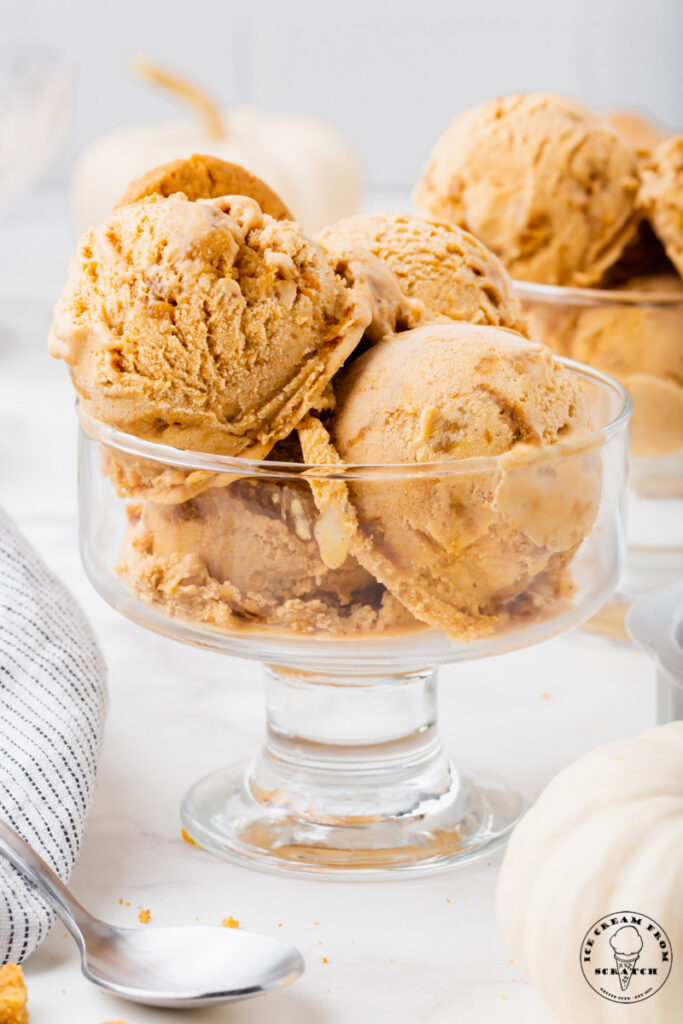Four scoops of homemade pumpkin pie ice cream in a glass dessert dish.
