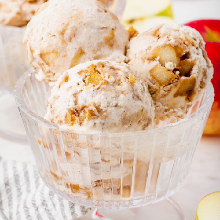 Three scoops of homemade apple pie ice cream in a glass footed ice cream dish.