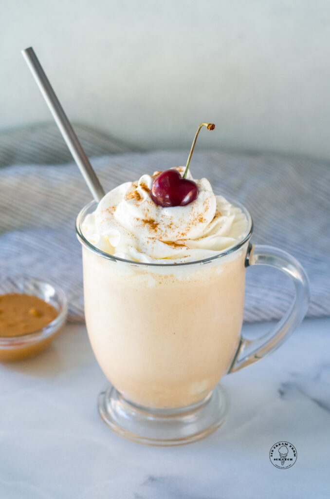 peanut butter milkshake with a straw and a cherry