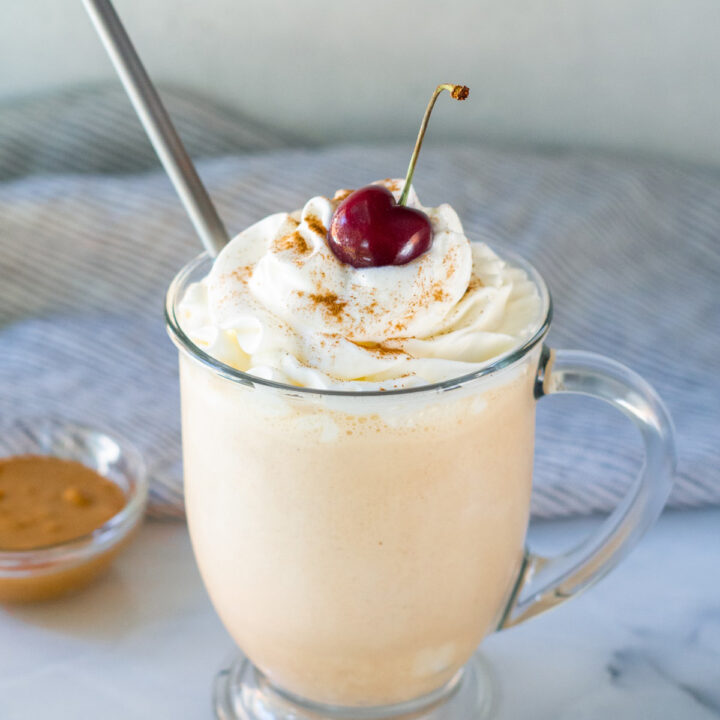 peanut butter milkshake with a straw and a cherry