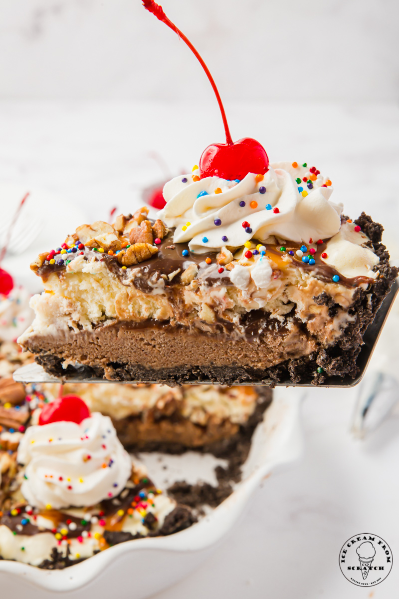 a slice of ice cream pie being lifted out of the dish. This pie has chocolate crust and layers of chocolate and vanilla ice cream inside.