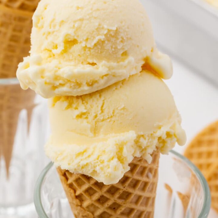 smooth, cream-colored mascarpone ice cream, two scoops on top of a sugar cone that is propped up in a glass.