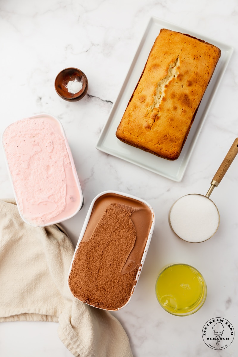 The ingredients needed to make baked alaska, including a pound cake, chocolate and vanilla ice cream, and egg whites.