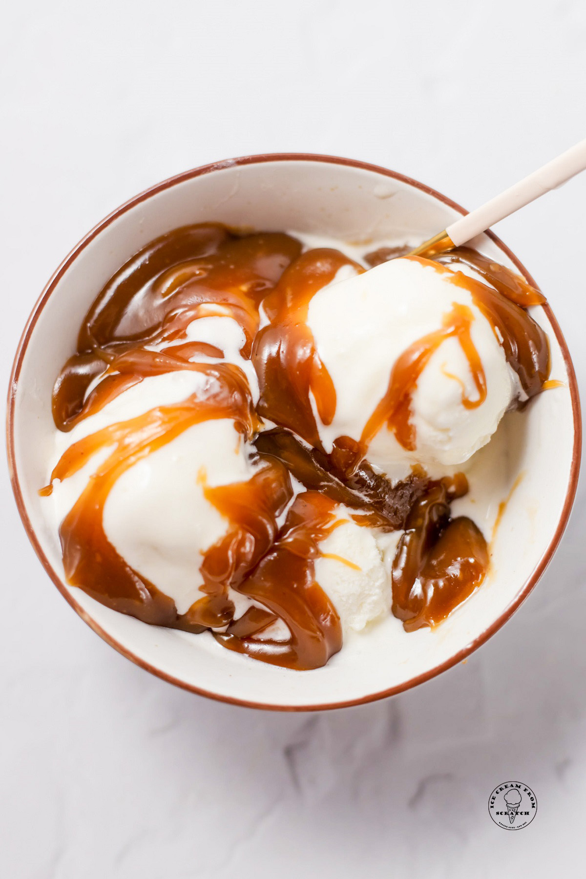 A bowl of vanilla ice cream topped with homemade peanut butter sauce.