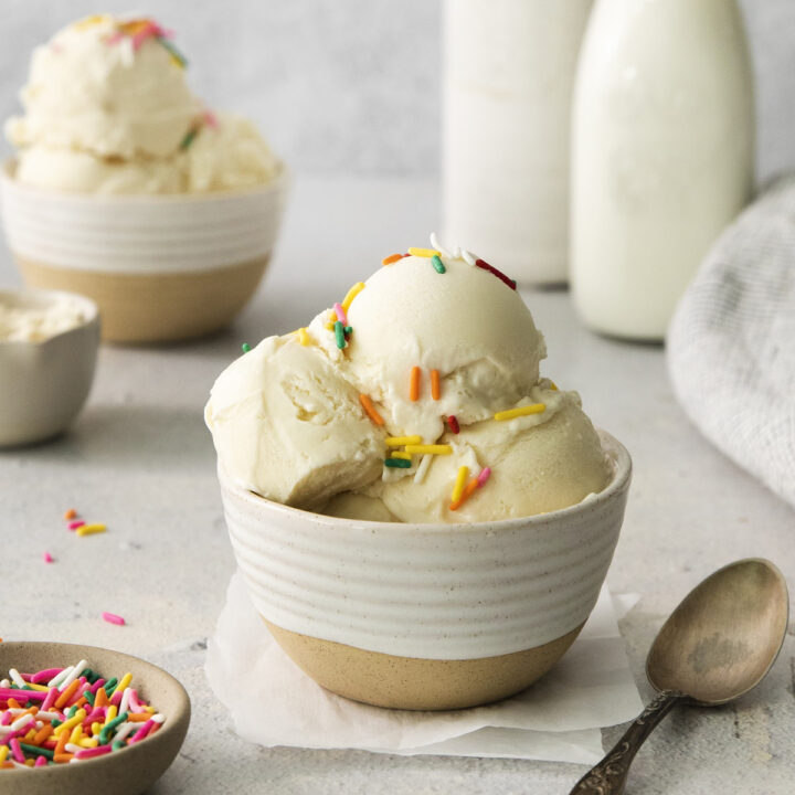 a ceramic bowl holding three scoops of protein ice cream topped with sprinkles.