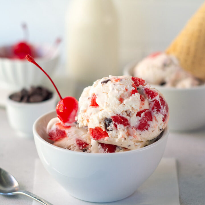 A bowl of homemade cherry cordial ice cream with a cherry on top