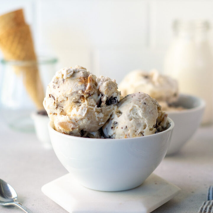 scoops of no churn fat elvis ice cream in a bowl with swirls of peanut butter and banana.