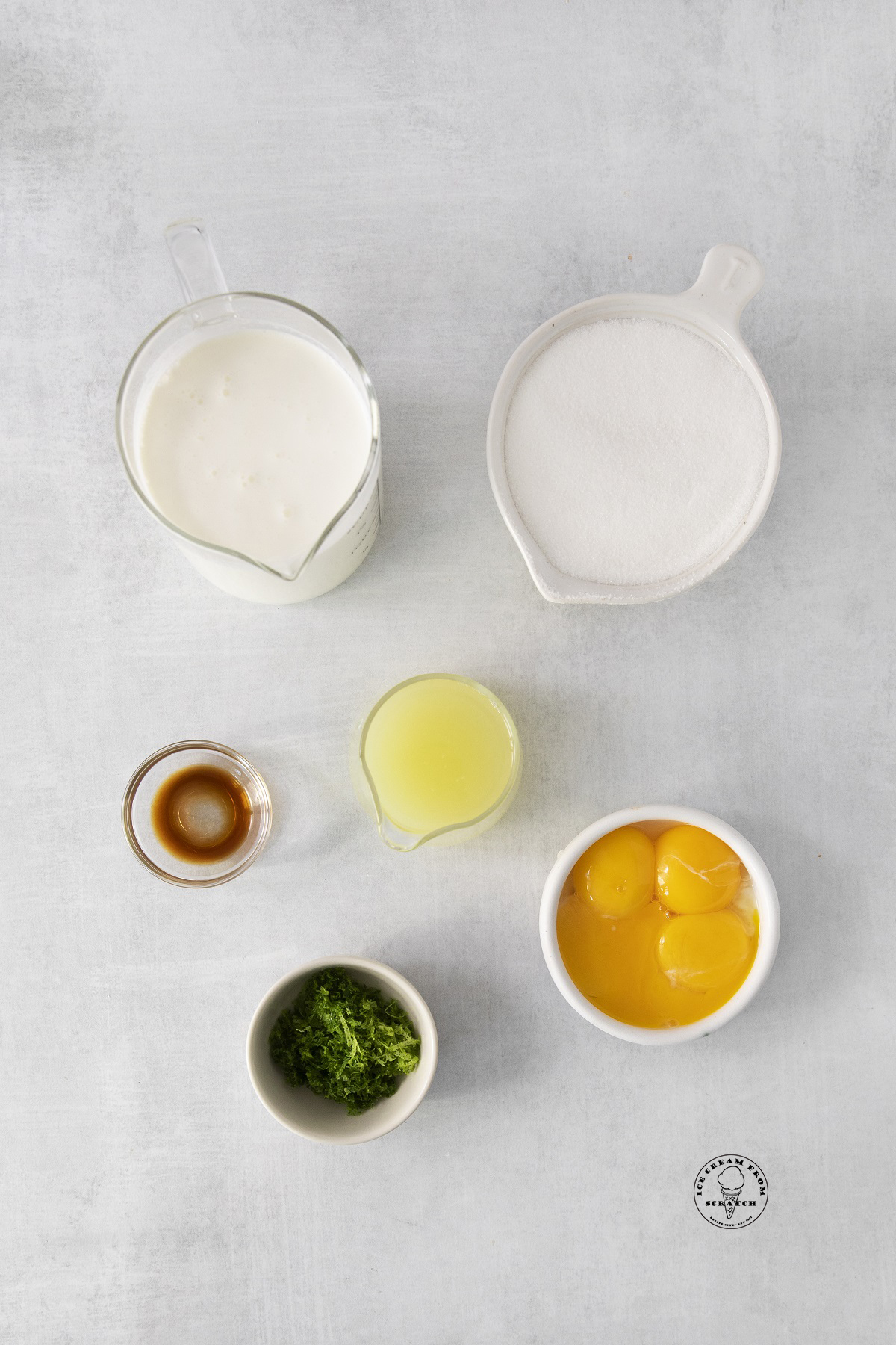 The ingredients for lime ice cream in separate bowls, arranged on a counter