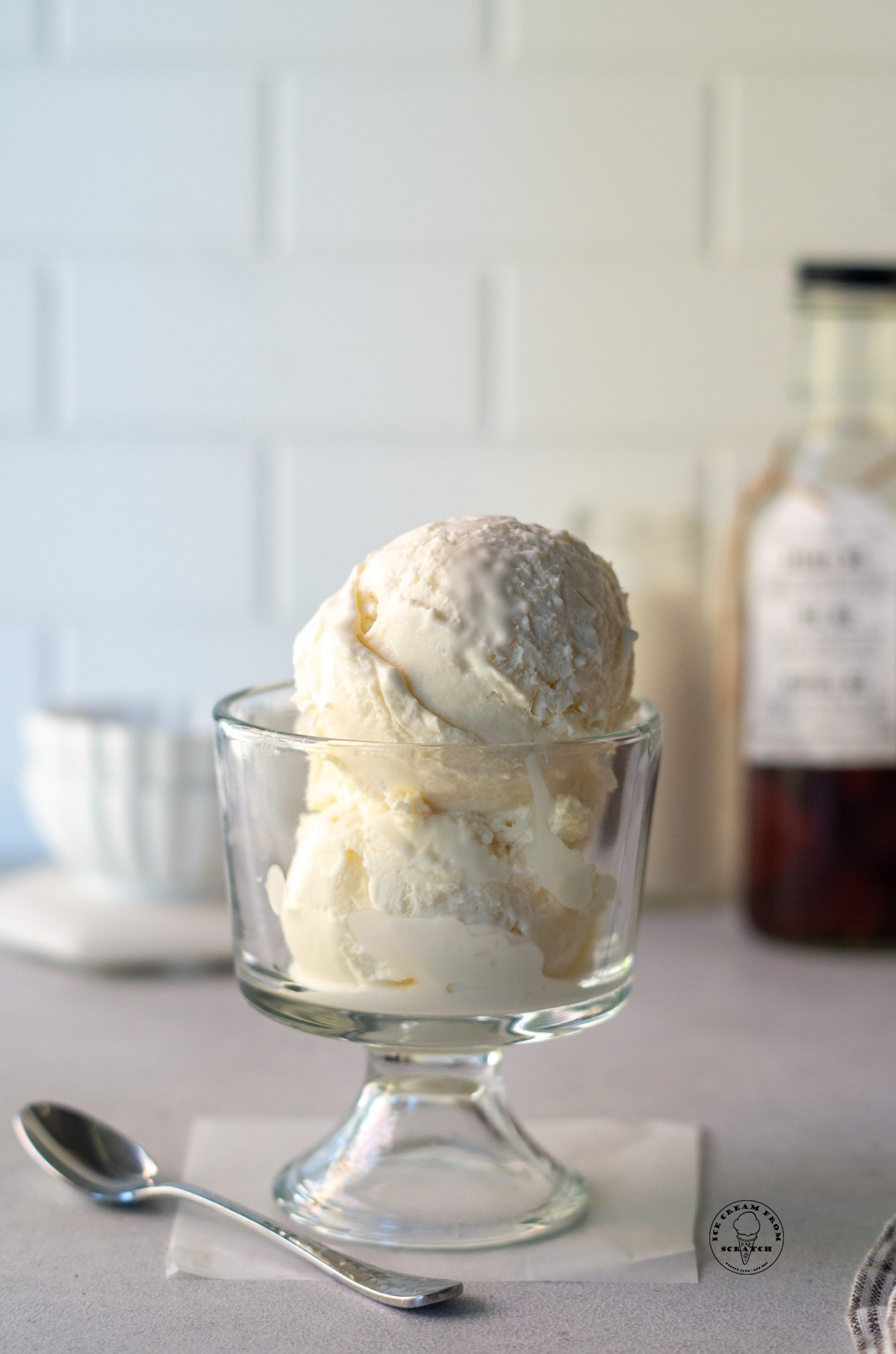 scoops of vanilla ice cream in a glass footed dish.