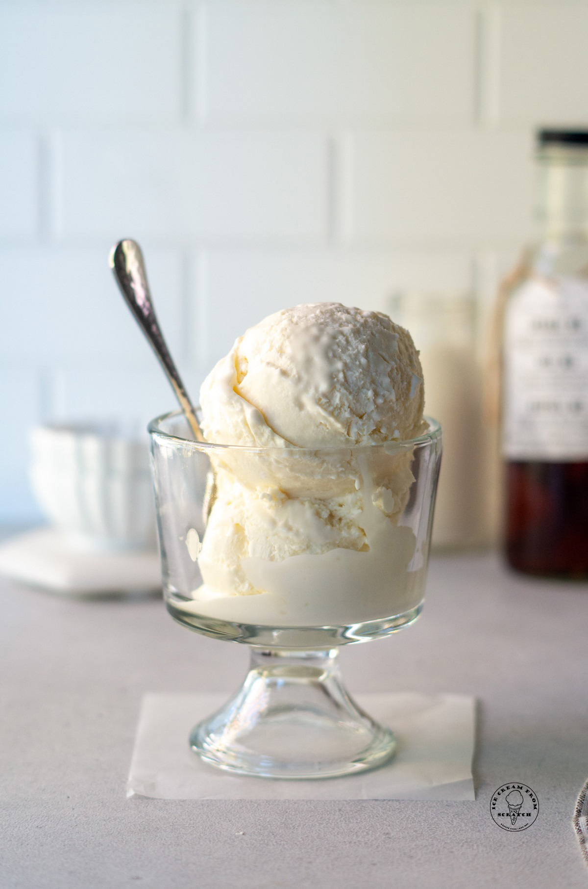 a glass dish of mexican vanilla ice cream with a spoon in it.