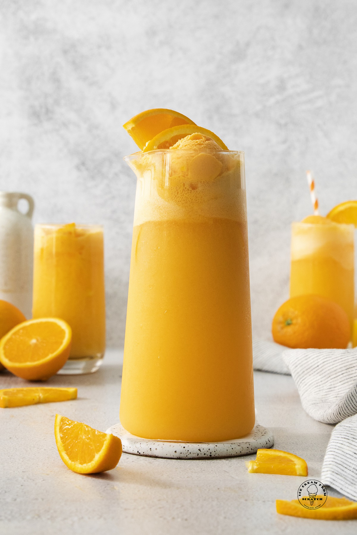 a large pitcher of orange punch with sherbet.