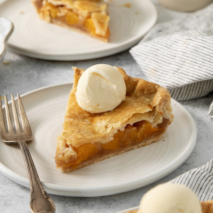 Slices of canned peach pie topped with vanilla ice cream.