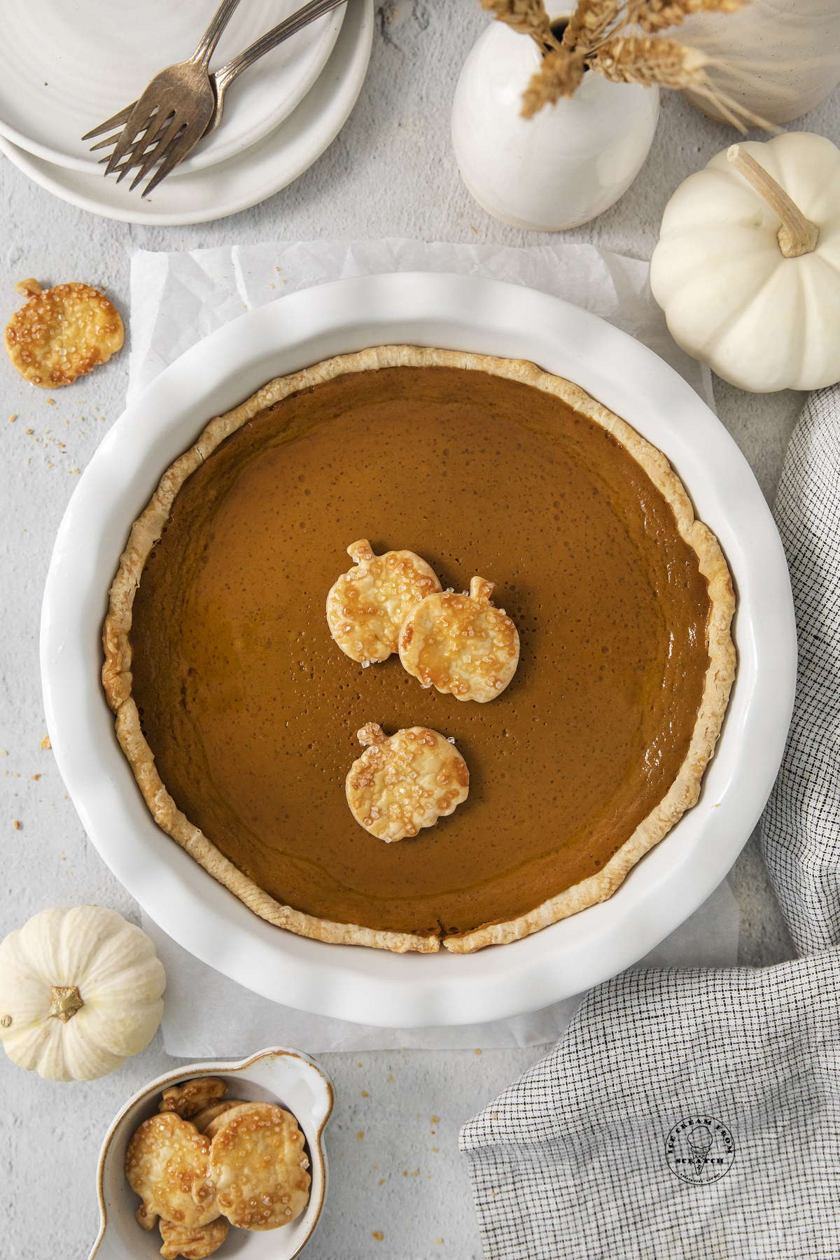 a baked pumpkin pie topped with small pumpkin shapes made from pie crust dough.