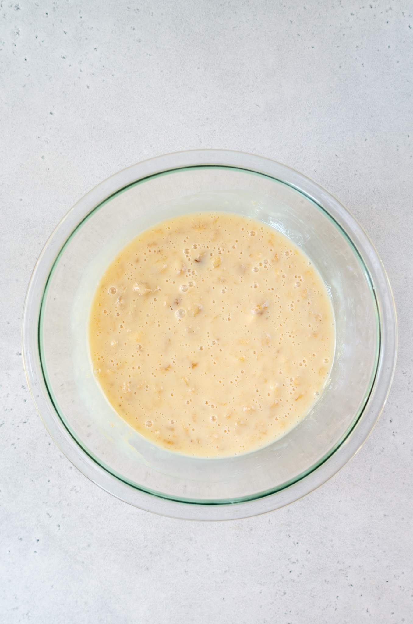 sweetned condensed milk and vanilla and banana in a mixing bowl mixed up