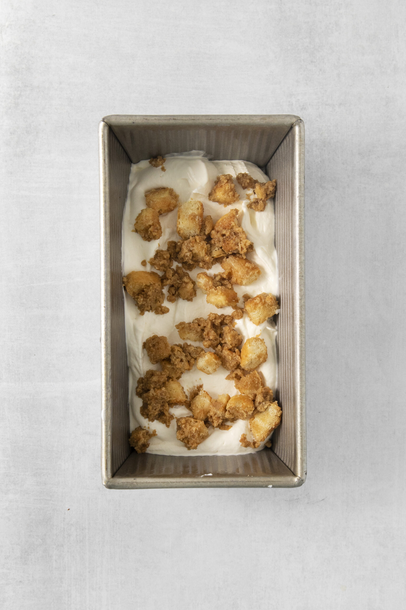 tiramisu ice cream layered in a loaf pan with ladyfingers