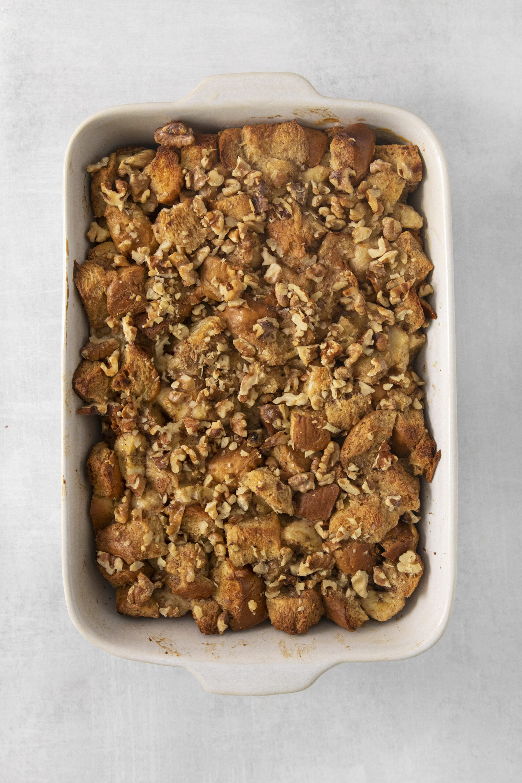 banana bread pudding mixture in a white baking dish