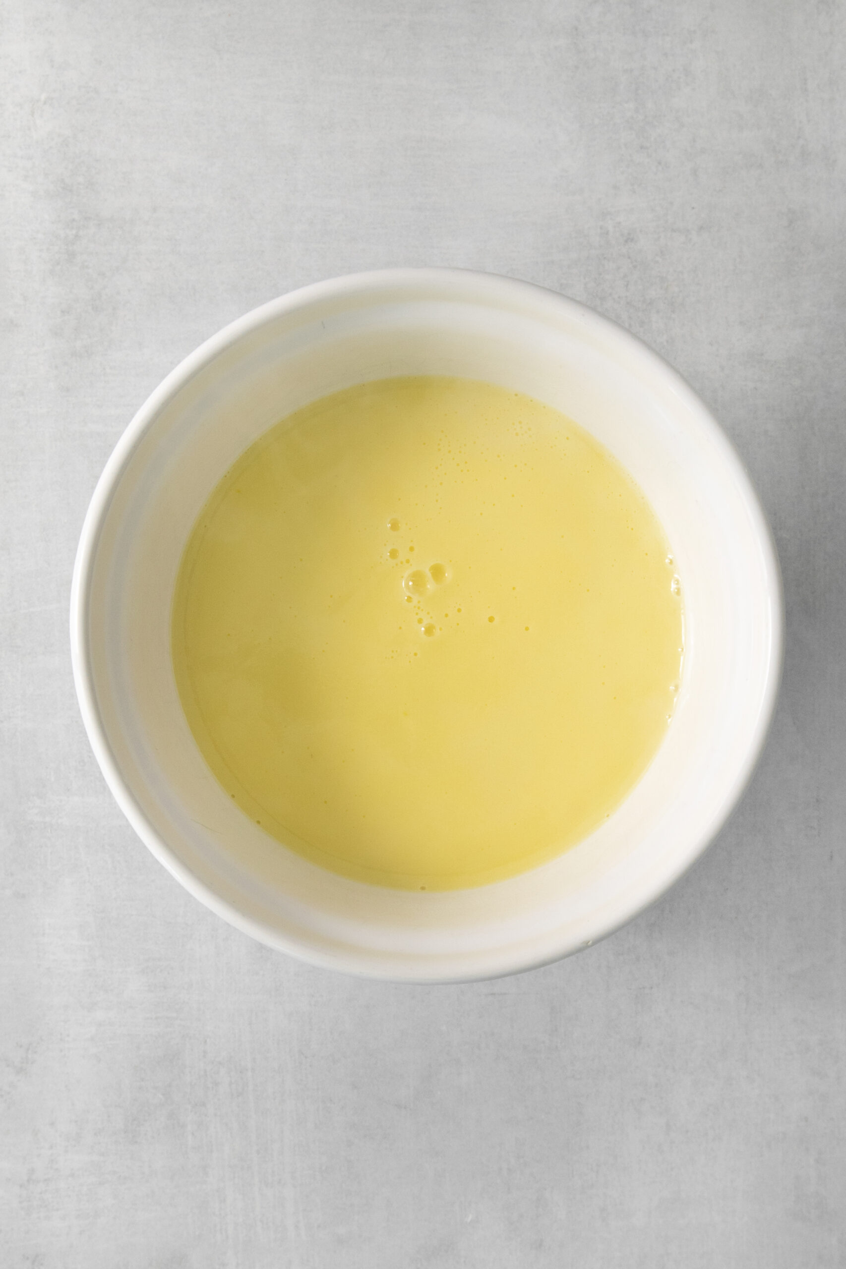 tempering the egg by adding in hot milk a little at a time