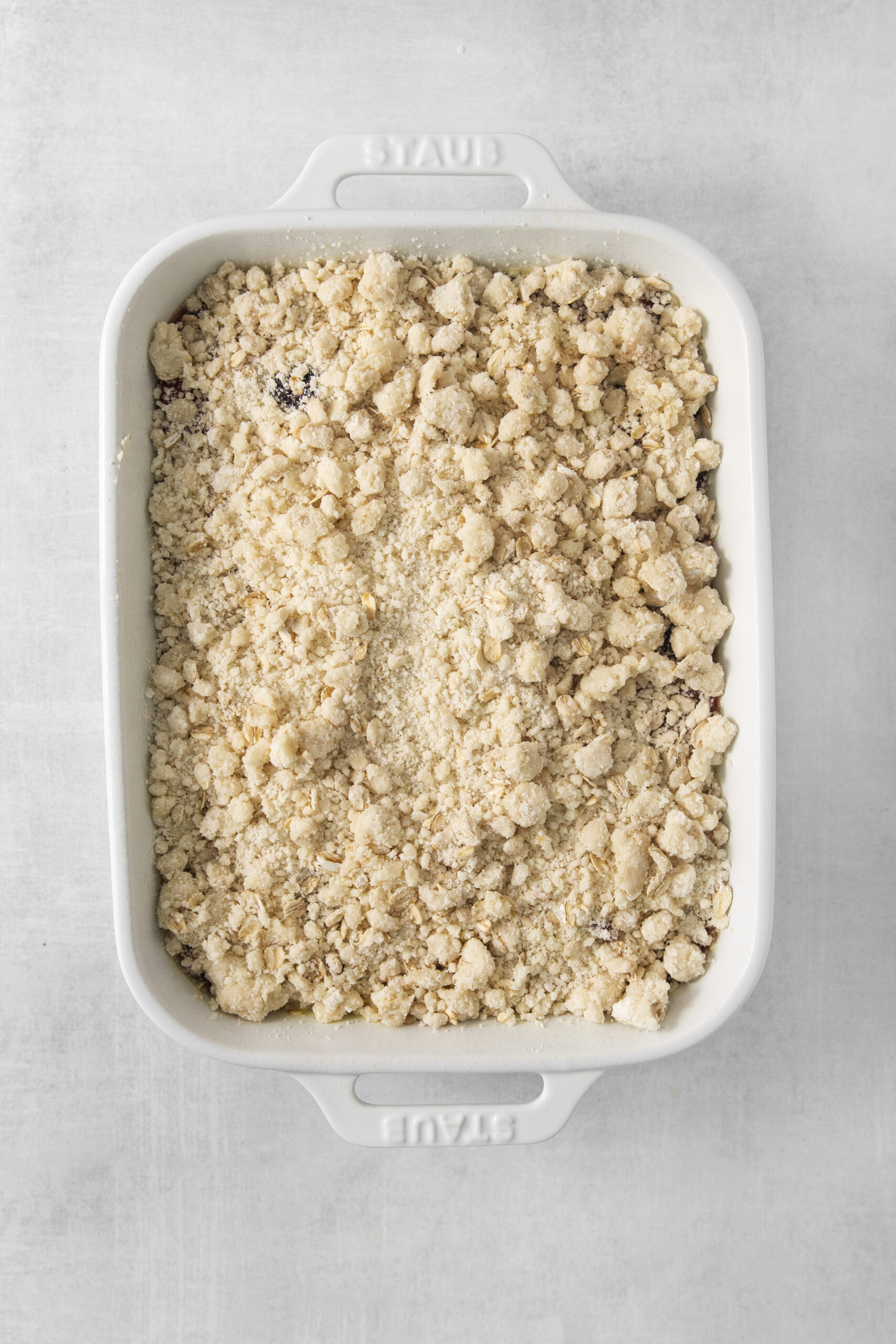 cherry cobbler uncooked in a white baking dish