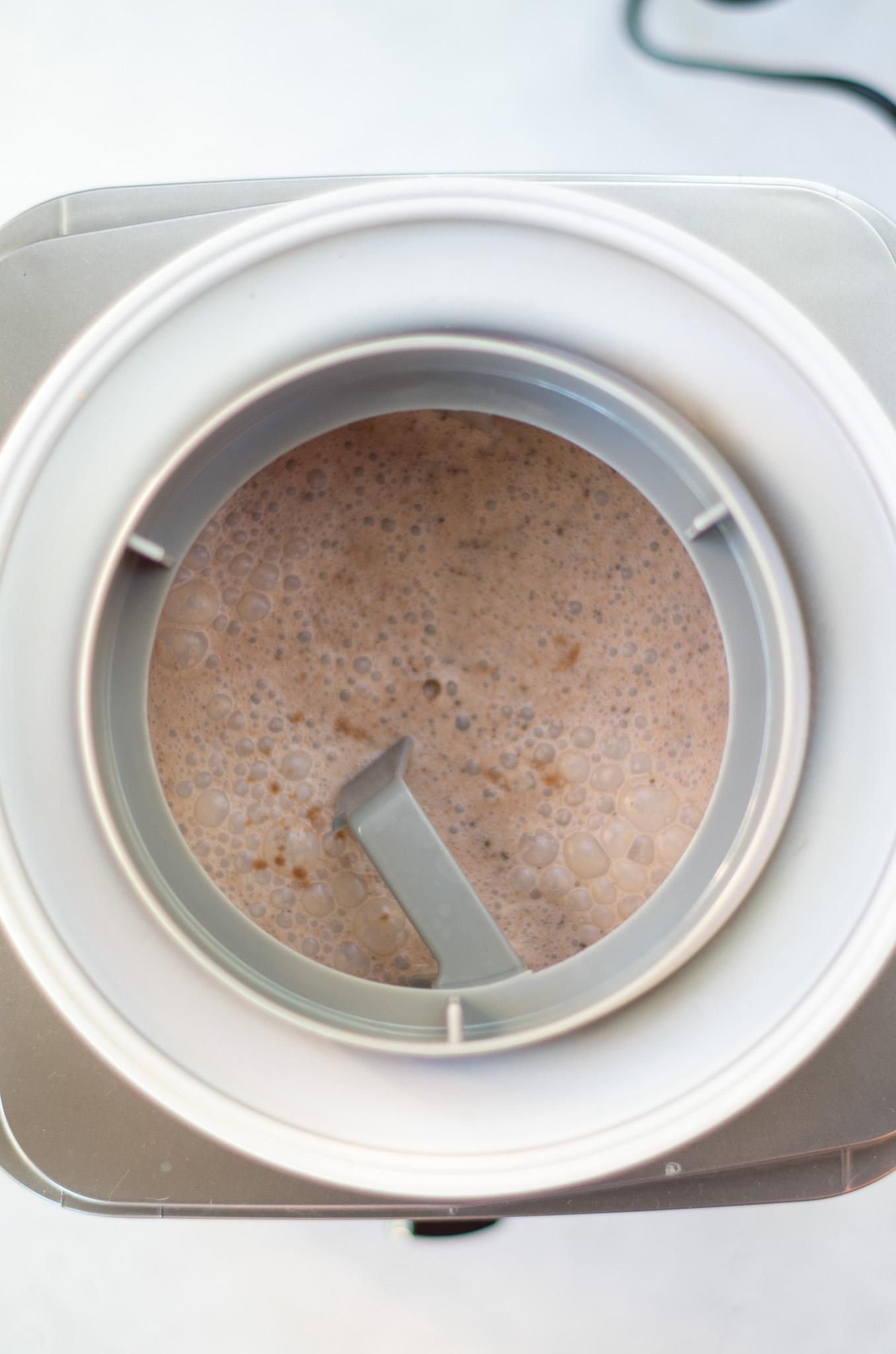 chocolate ice cream mixture in an ice cream maker bowl