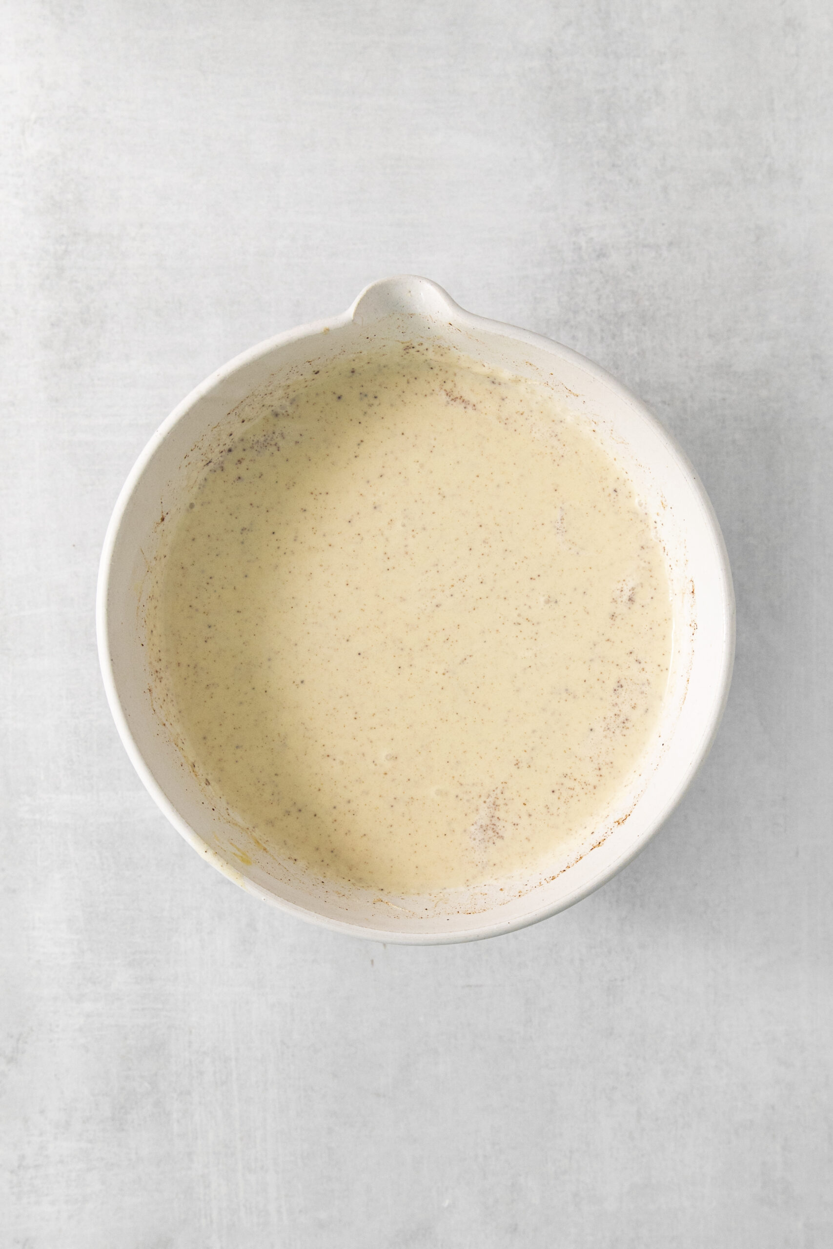 custard mixture for ice cream base in a bowl mixed with cinnamon