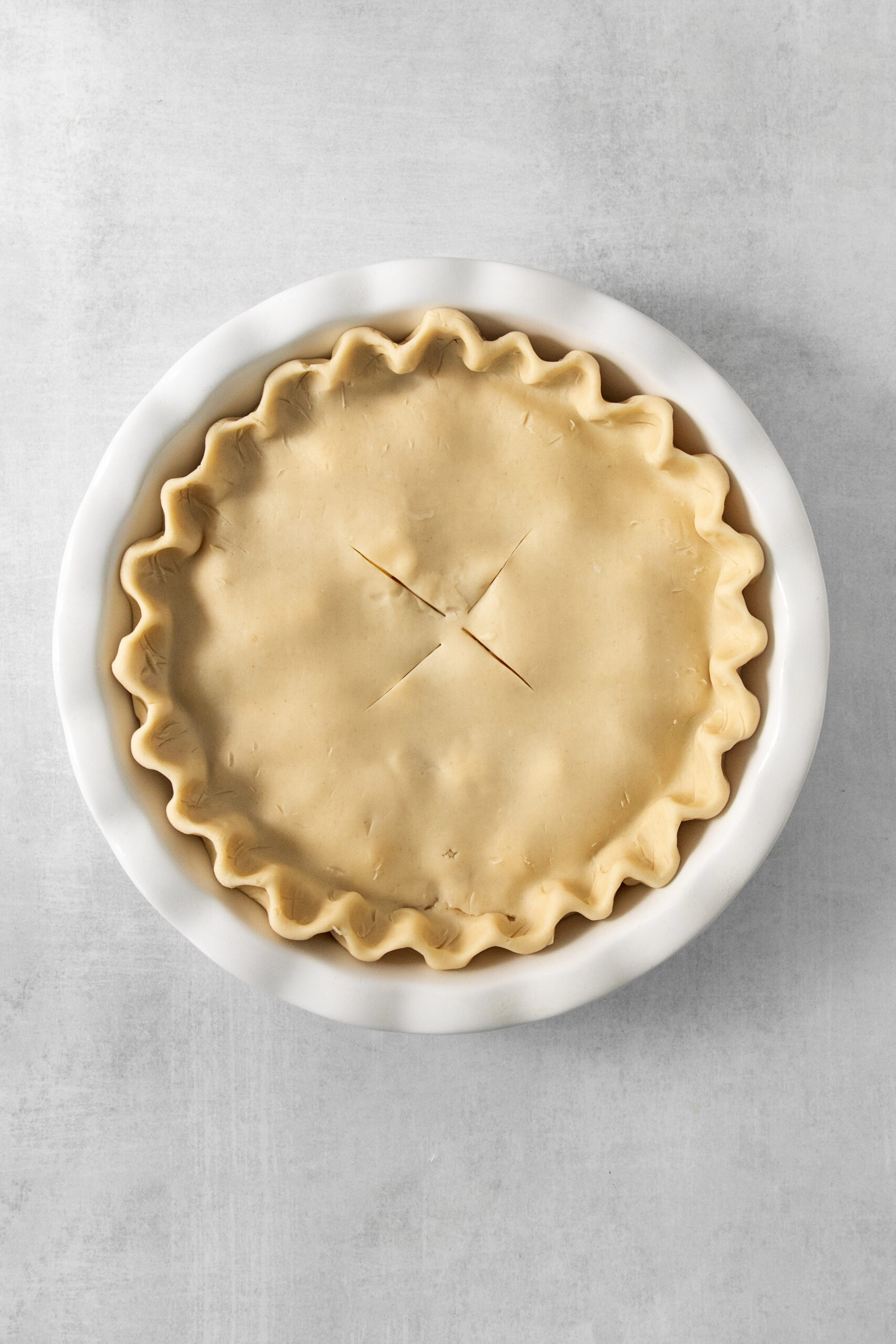 uncooked peach pie with canned peaches in a pie pan